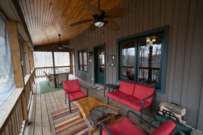 The screened-in porch has a full dining table and additional seating area.