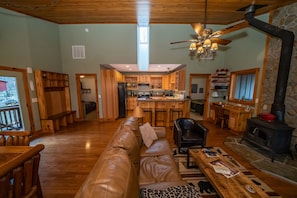 Main living area featuring a wood stove and flat-screen TV