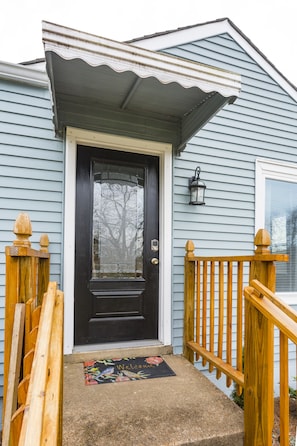 Covered front porch entrance to the home has smart lock with keypad.