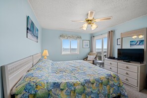This spacious primary bedroom has a king bed, en-suite bath, & balcony access.