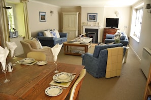 Large living/dining area with working wood burning stove, opening onto a well equipped kitchen