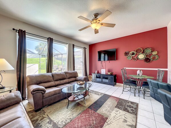 Spacious living room with large windows and cozy seating for your comfort.