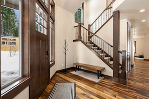 Two story entry way greets you with coat rack and bench for putting on/off shoes