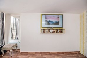 Clean, neat bedroom with ample sunlight from the big window and balcony