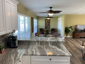 Bar off kitchen to dining table and setting room overlooking the dock.