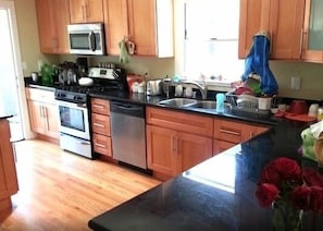 Kitchen with breakfast bar opens out to backyard patio 