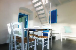 Downstairs dining area. All-new modern table and white painted taverna chairs.