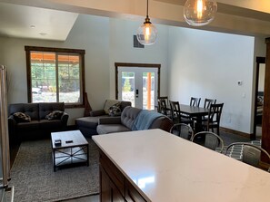 Open kitchen to living room to dining area, bar stools, french doors to patio. 