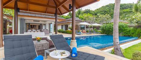 Relax by the outdoor lounge area with 2 single lounge chairs by the pool.