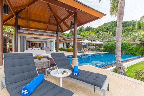 Relax by the outdoor lounge area with 2 single lounge chairs by the pool.