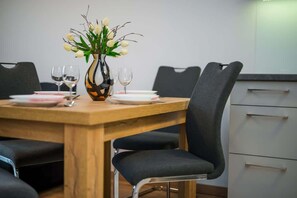 A dining area with black chairs, and a decorative plant, giving a modern yet inviting feel to the space.