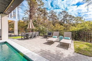 Sunny Paver Patio with Loungers and Outdoor Dining 
Cafe Lights above for night time ambiance