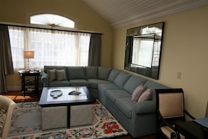 Living room: sleep sofa, coffee table/4 seats, dining area on the right.