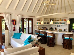 Main living space with kitchen in the background w/ ocean view from each corner
