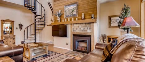 Living room with spiral staircase to loft and master bedroom