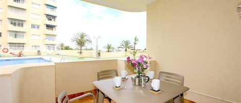 Private terrace with outdoor dining area for four guests and pool views