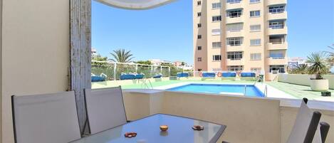 Terrace with outdoor dining area for four guests and views to the pool