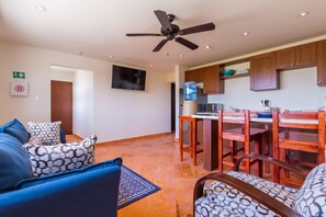 Living area with TV, full kitchen and kitchen bar