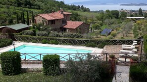 View from balcony showing pool and Lago Trasimeno in background.