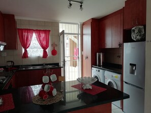 Kitchen with washing machine and tumble dryer