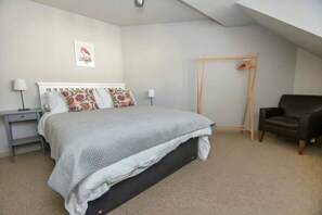 Bedroom 1
Upstairs there is a contemporary, stylishly decorated bedroom with a king size bed, side tables and lamps, drawers and an open, wooden hanging rail.