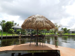 Tiki hut out on the dock with 4 bar stools