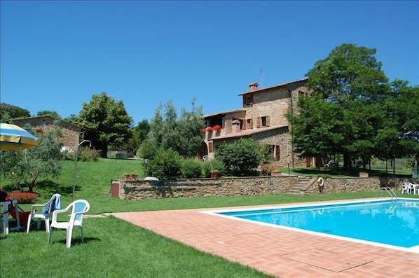 View of the whole farmhouse, with the garden and the pool