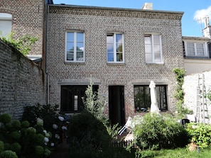 Vue de la maison : jardin paisible et ensoleillé 