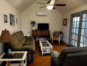 Cozy living room with high ceilings and 50 inch TV with cable.