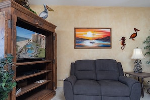 Large TV center and recliner in the living room.