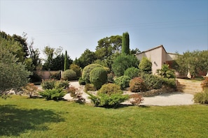 Jardin paysagé, à droite, accès annexe et terrasse