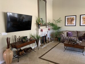 Living room with cozy fireplace and 65” HD TV