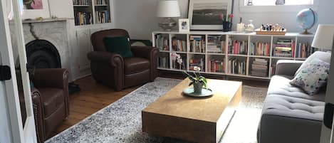 Cozy living room with large book collection. 