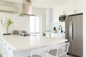 Kitchen features modern appliances and a breakfast bar.