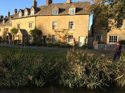 Period cottage in idyllic riverside location in prime Cotswolds village