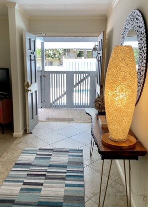 View from entrance hall through front double doors toward pool.