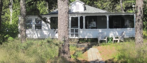 Front view. Screened porch entrance. Boardwalk leads to  sandy beach out front.