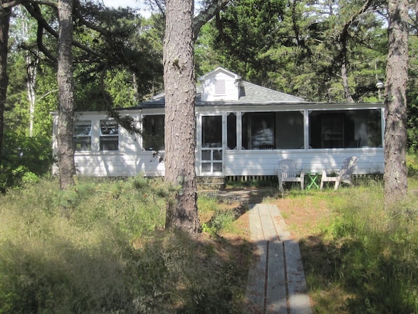 Front view. Screened porch entrance. Boardwalk leads to  sandy beach out front.