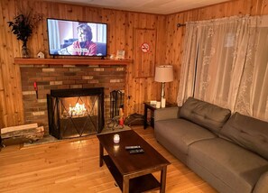 Livingroom area with 43 inch tv, real wood fireplace & fake fireplace available