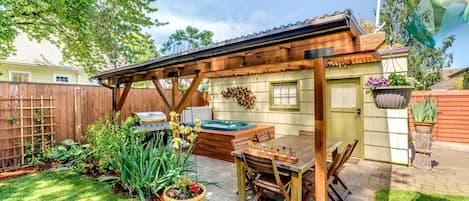 "[H]ot tub under awning, their backyard is a beautiful space in any weather." 