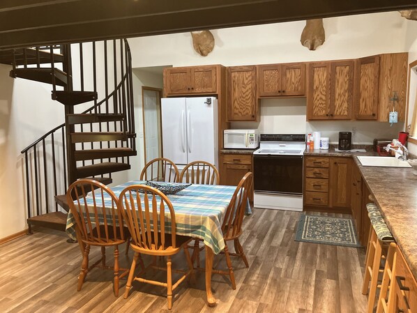 View of dining area, kitchen and the spiral stair to the sleeping loft.