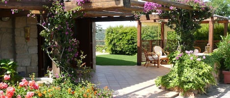 Villa facade, a veranda full of colourful flowers.