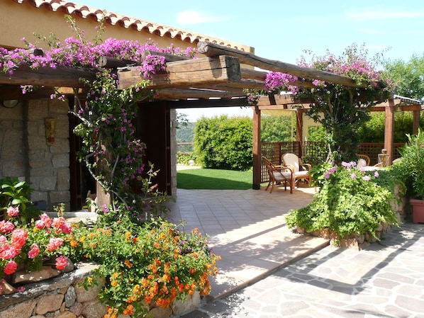 Villa facade, a veranda full of colourful flowers.