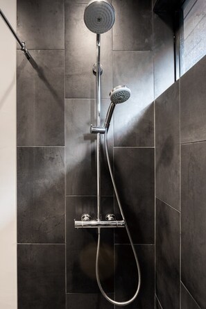 Choose from three luxurious shower heads in the sleek, black bathroom.