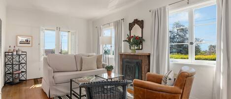 Quaint living room with sitting area and bright windows