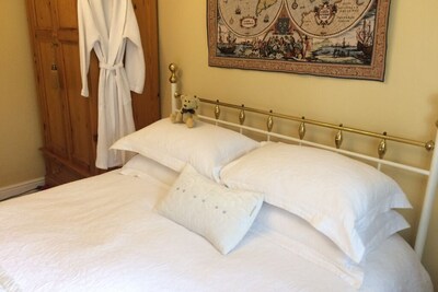 Una cama King Size con baño privado en una casa de lujo con vista