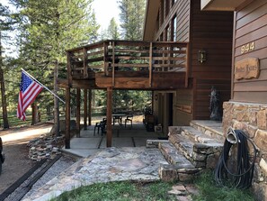 North-facing view of the entry with the lower patio and upper balcony behind.