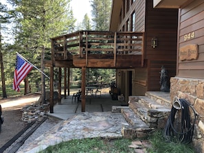North-facing view of the entry with the lower patio and upper balcony behind.