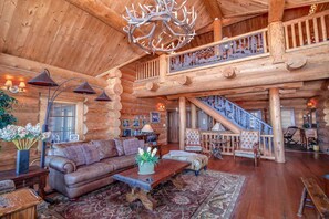 Great room with antler chandelier, vaulted ceilings, logs throughout!