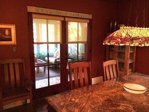 The casual dining room off of the kitchen opens onto the screen porch and pool.